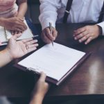 male hand putting signature, running own small business, have a contract in place to protect it, basics of writing contract, one sentence in a contract can cost a business